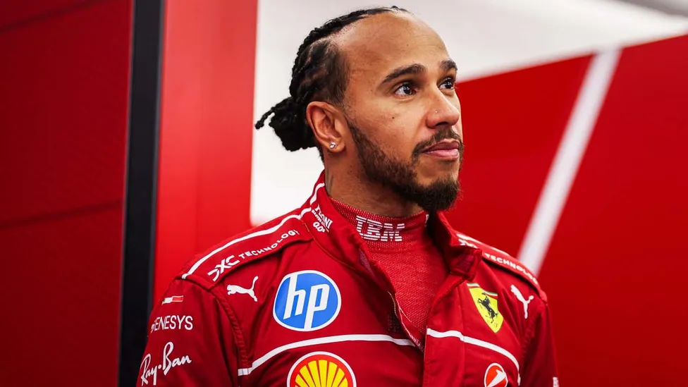 Льюис Хэмилтон — 3/4 портрет, красная форма Ferrari, гараж