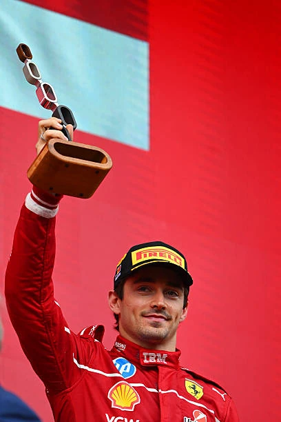 Шарль Леклер — подиум, поднимает кубок, красная форма Ferrari