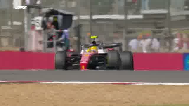 Ferrari поднимает фонтан гравия на обочине Сильверстоуна.