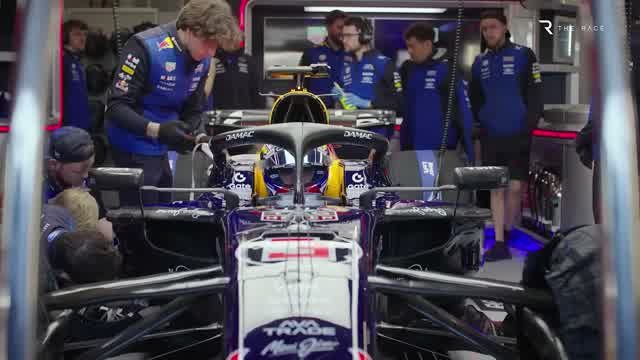 Механики Red Bull над машиной в гараже